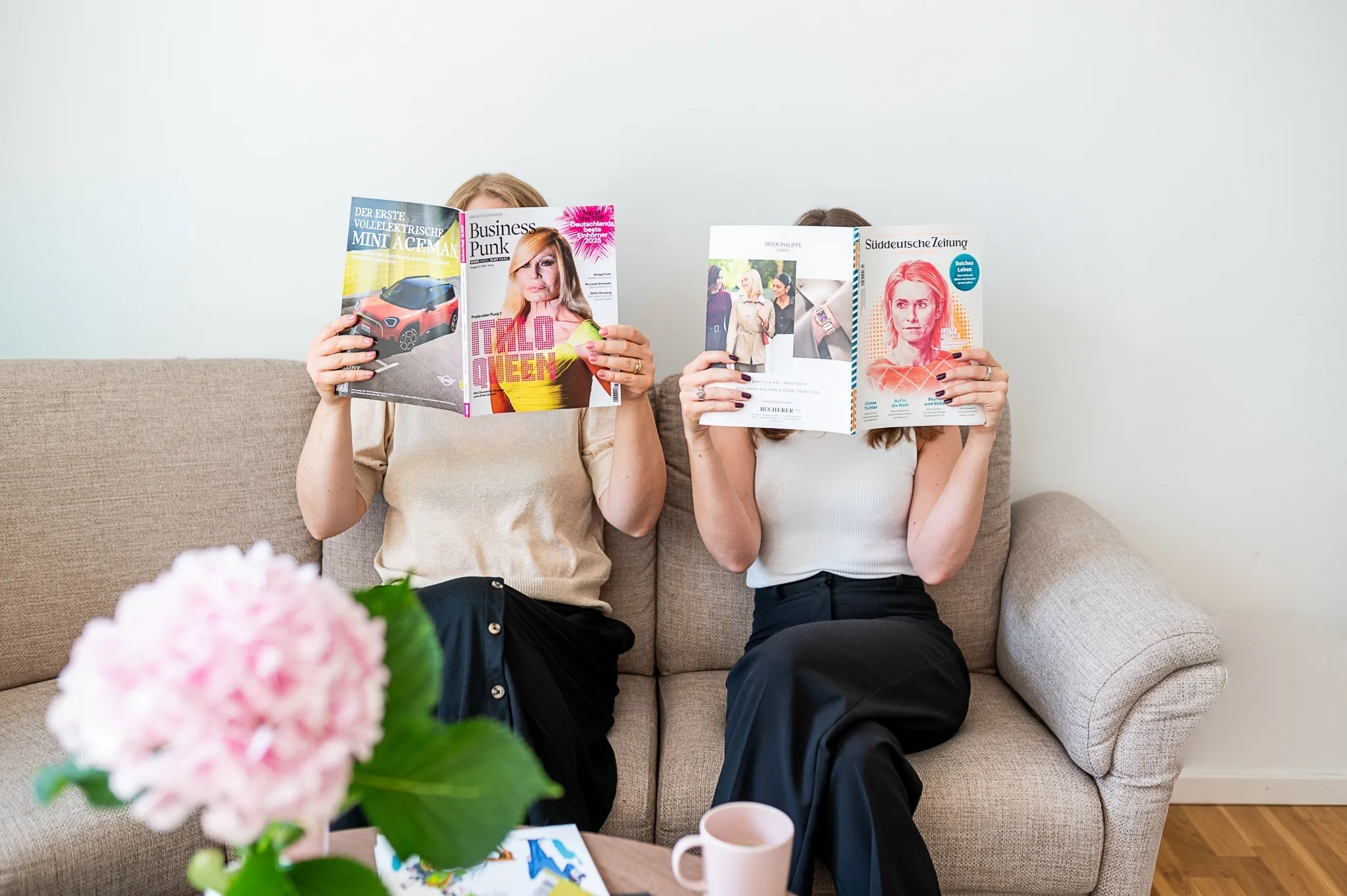 Marie Franz und Sophia Lock lesen Magazine auf dem Sofa