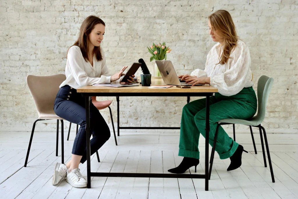 Marie Franz und Sophia Lock, Gründerinnen der PR-Agentur Pressegold Berlin, arbeiten gemeinsam an einem Tisch
